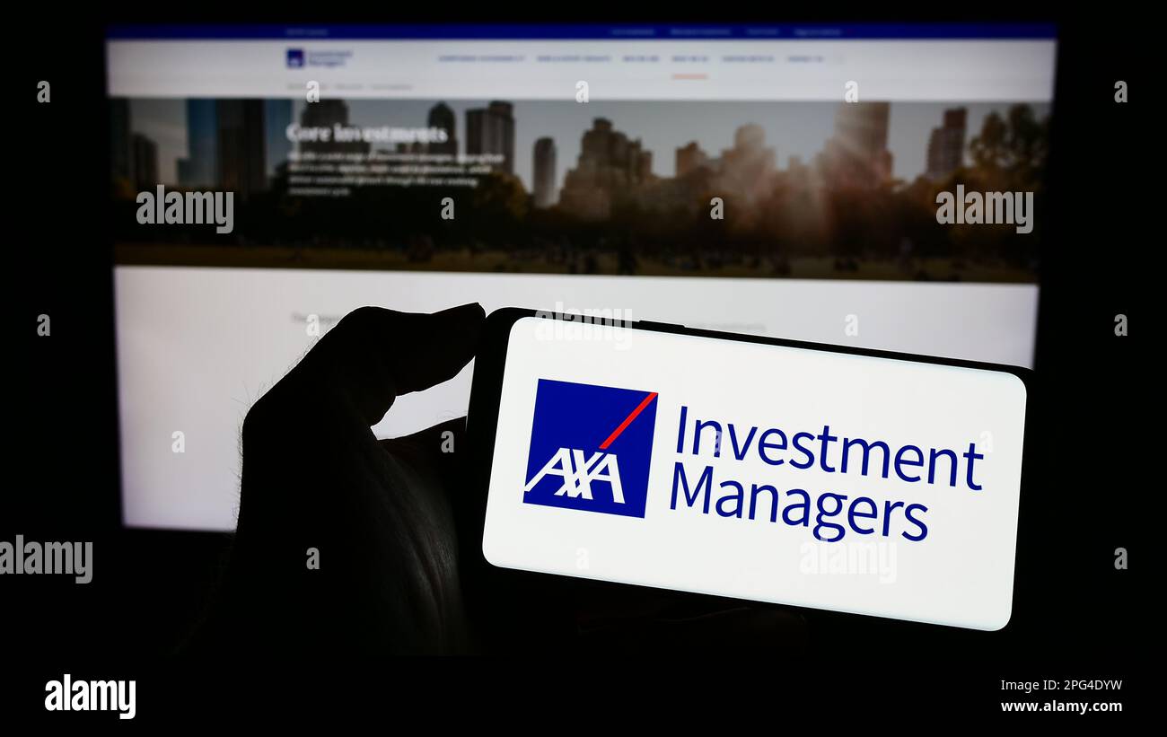 Person holding cellphone with logo of investment company Axa Investment Managers on screen in front of business webpage. Focus on phone display. Stock Photo