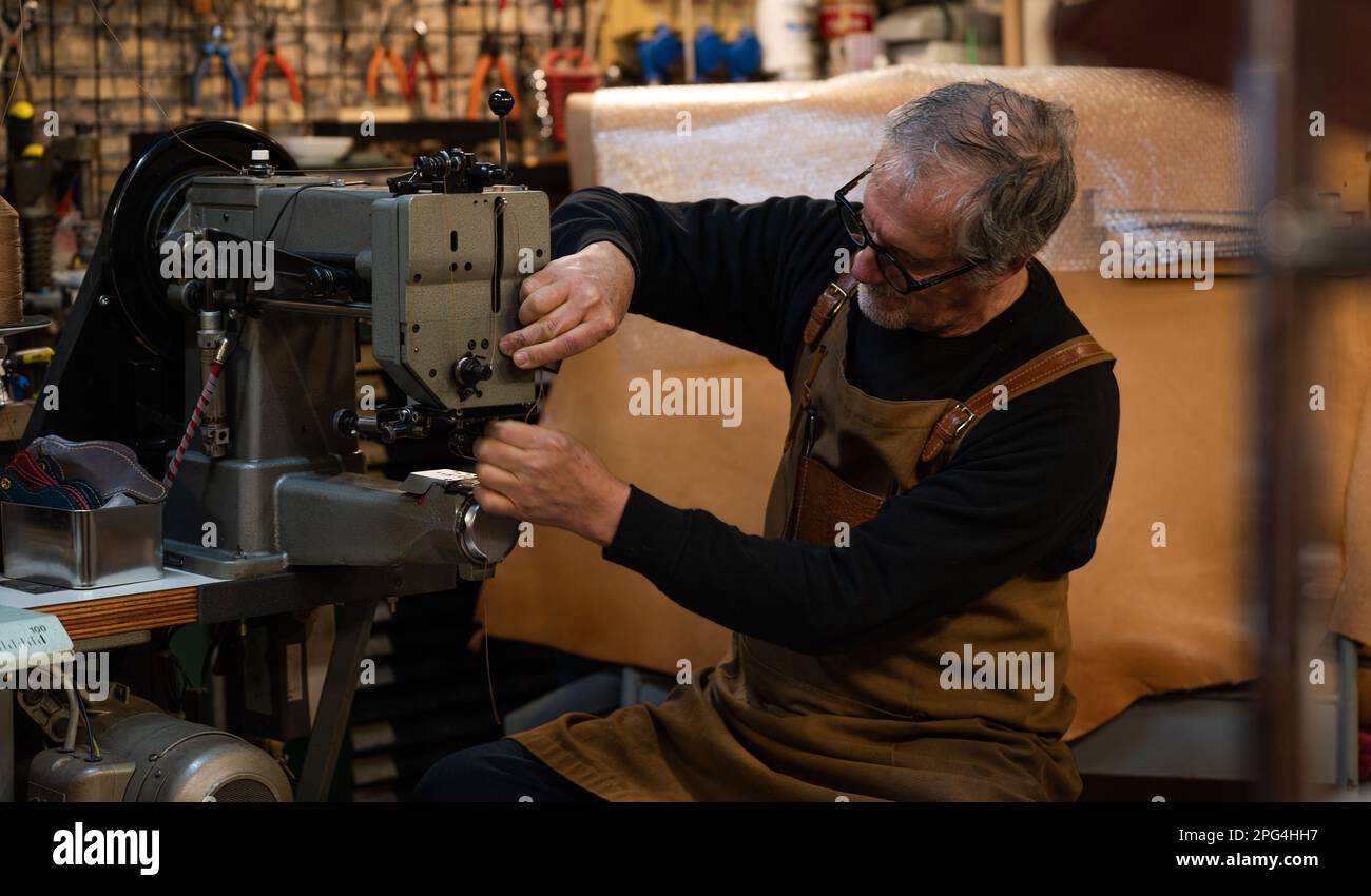 adult craftsman sitting adding thread in a sewing machine to start
