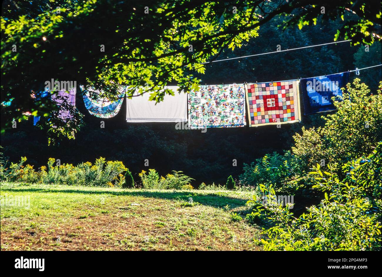 quilt hanging on clothesline in sunlight outdoor fresh air