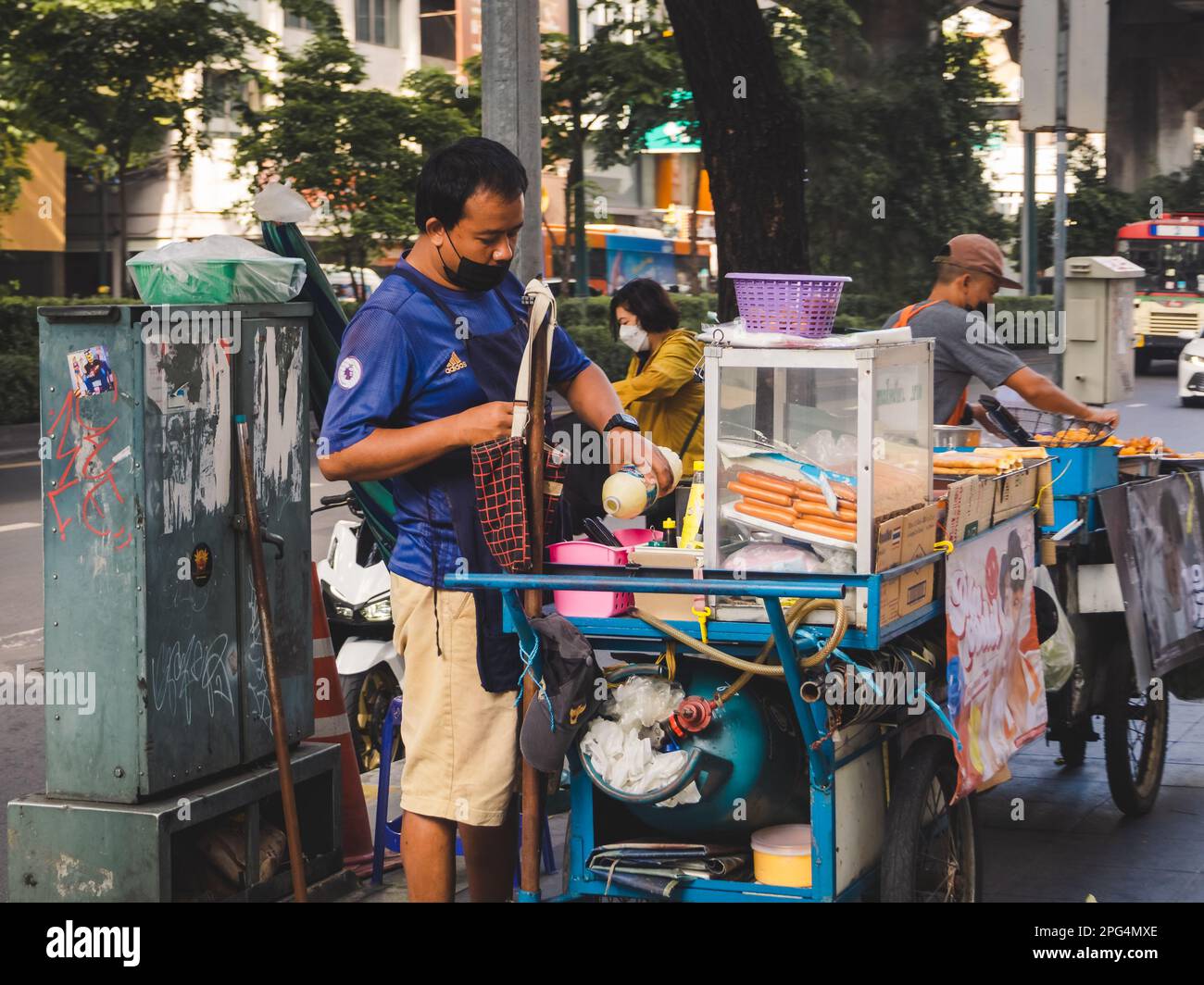 A vendor selling a variety of snacks from a mobile food cart Stock