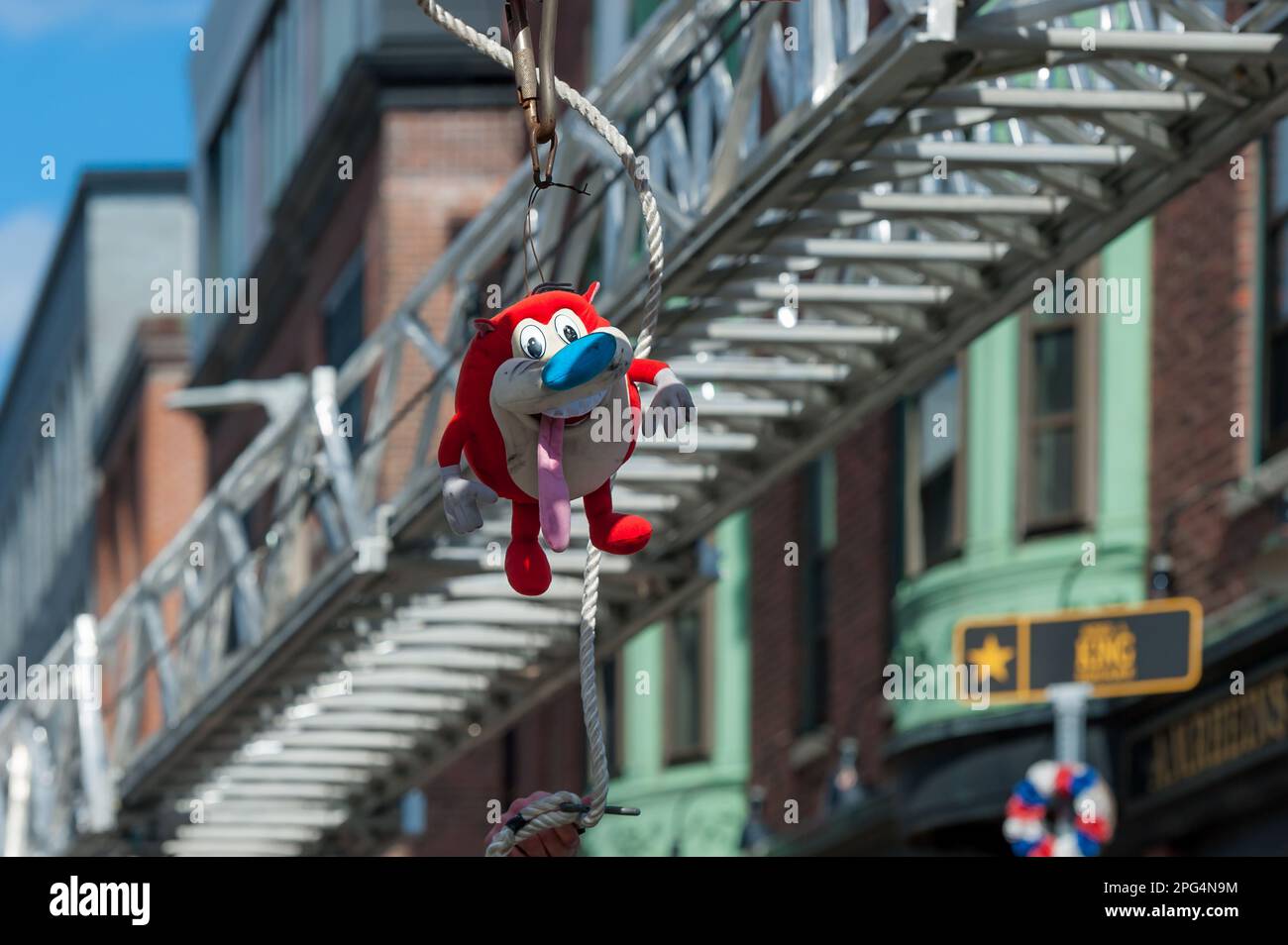 Stimpy stuffed toy hanging from Boston Fire Ladder truck at 2023 South Boston St. Patrick's Day and Evacuation Day Parade Stock Photo