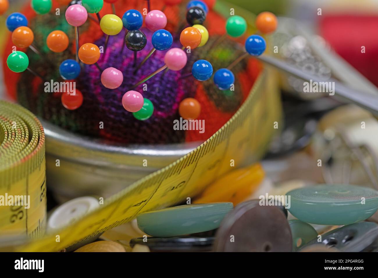 Pin cushion with lots of colorful pins in a close-up Stock Photo
