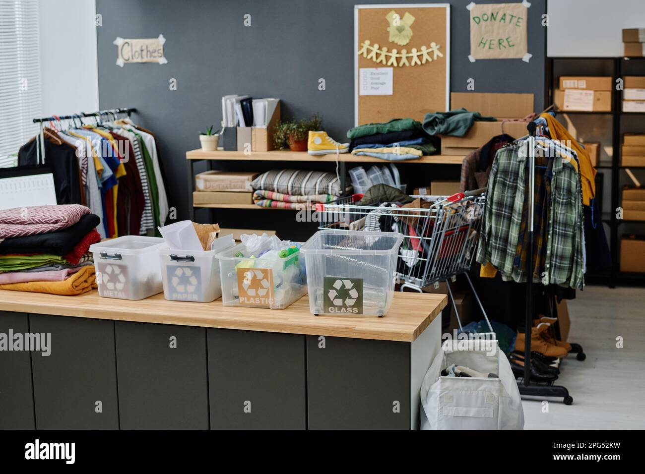 Row of plastic garbage bins with recycle symbol standing on desk