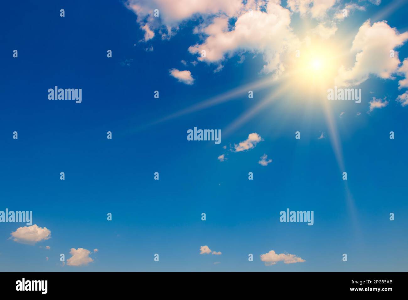Blue sky with white fluffy clouds and bright sun with rays Stock Photo ...