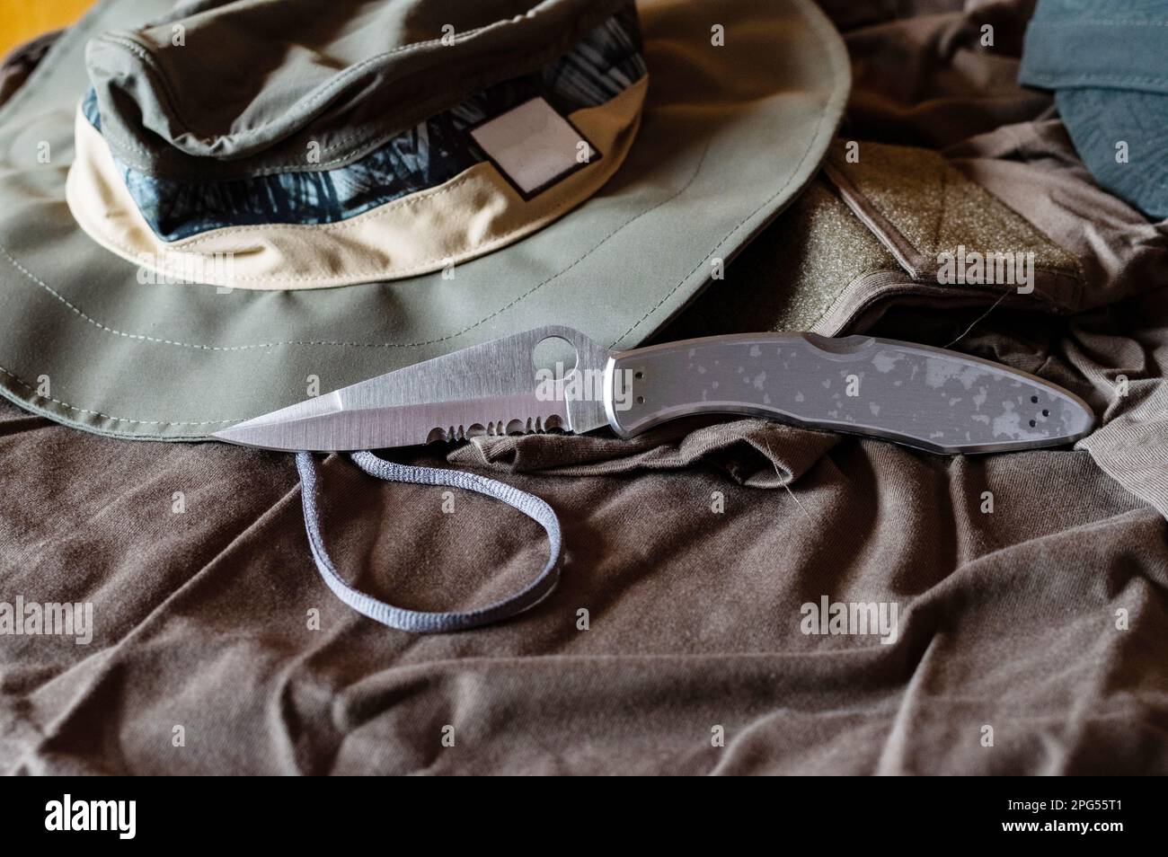 Pocket knife and military clothing. Knife with a serrated blade. Knife