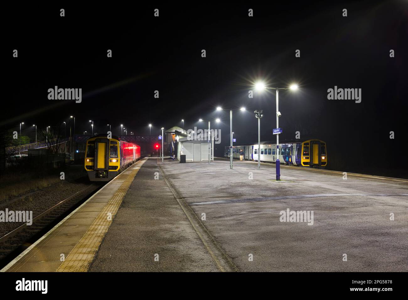 2 Northern Rail class 158 DMU trains  at Eaglescliffe railway station, Stockton on Tees, UK at night each side of the island platform Stock Photo