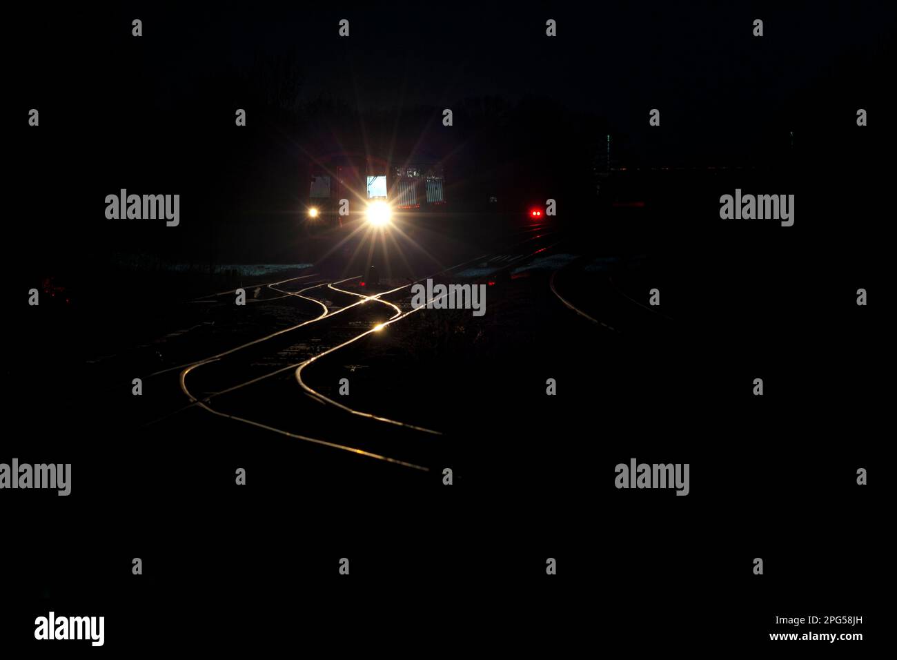 Northern Rail class 158 diesel trains headlights illuminating the track work ahead  as it waits in the reversing siding at Eaglescliffe at night Stock Photo