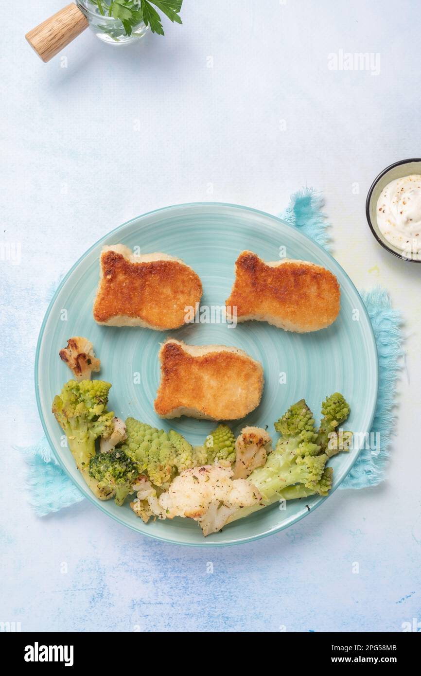 Kids food. Fish shaped nuggets with vegetable Stock Photo - Alamy