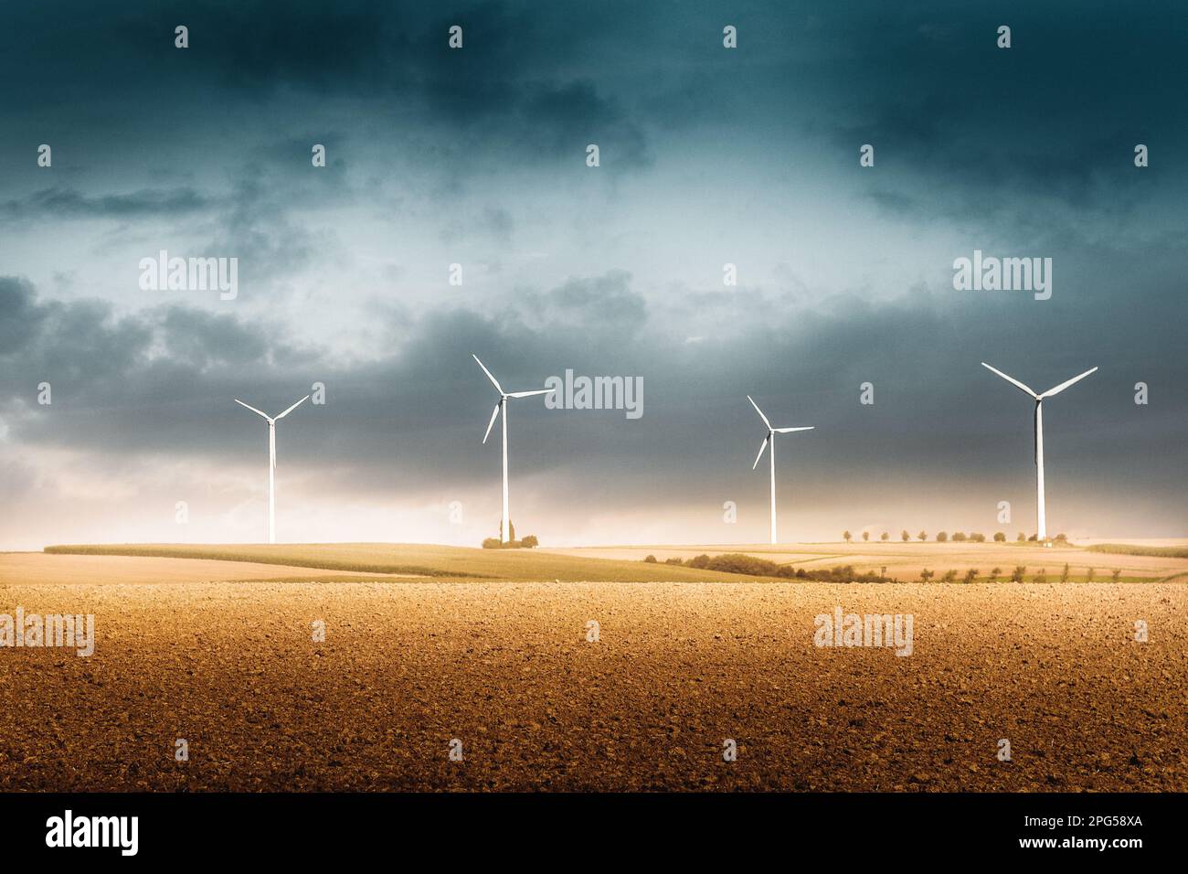 Wind turbines in the field under a cloudy blue sky by a windy day in ...