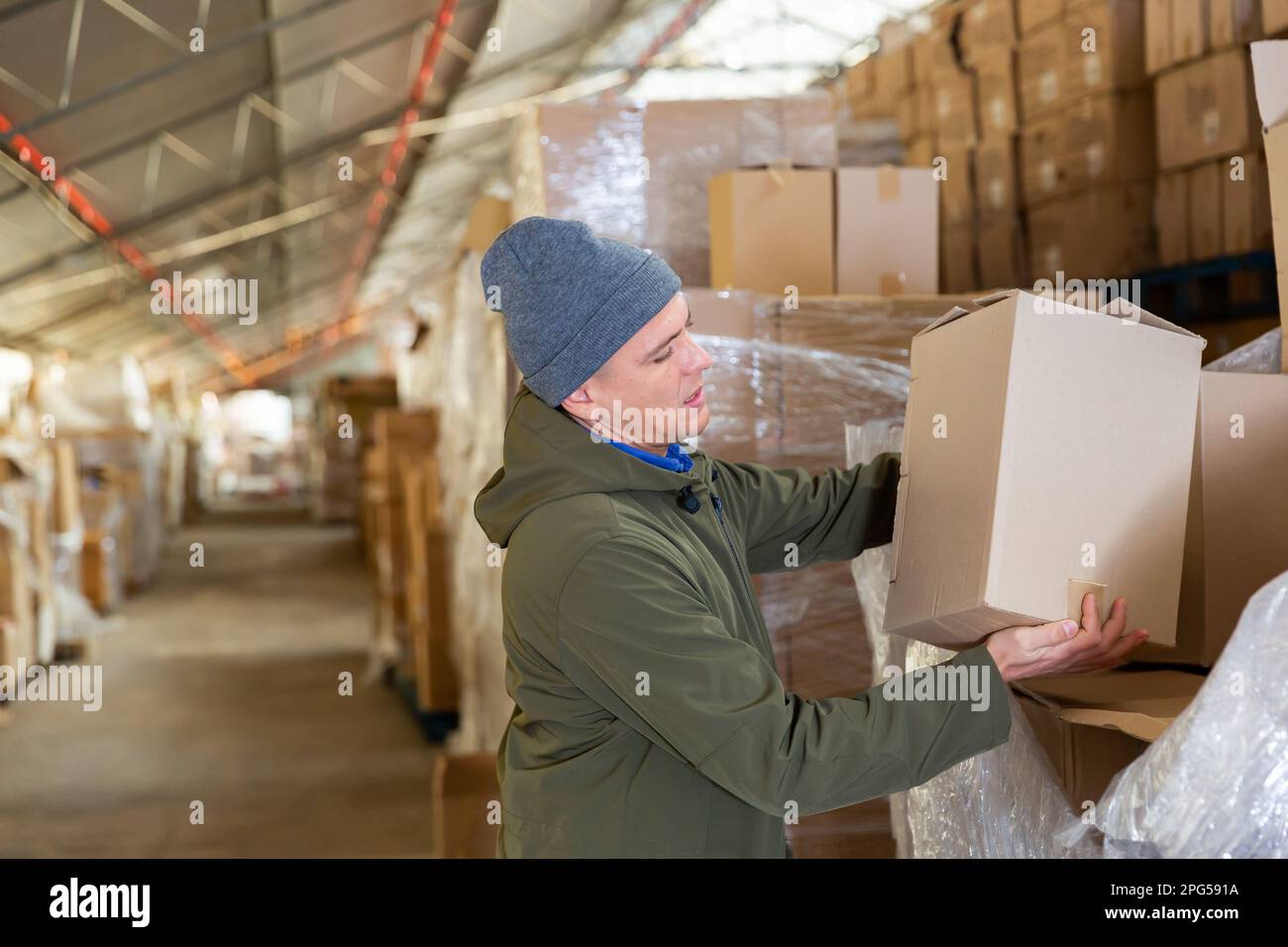 Warehouse worker carrying pasteboard box Stock Photo Alamy