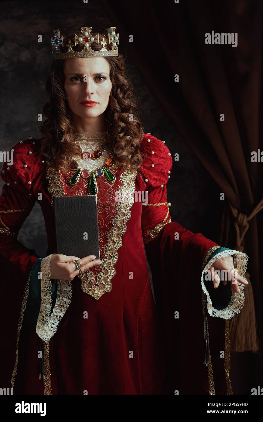 medieval queen in red dress with book and crown Stock Photo - Alamy