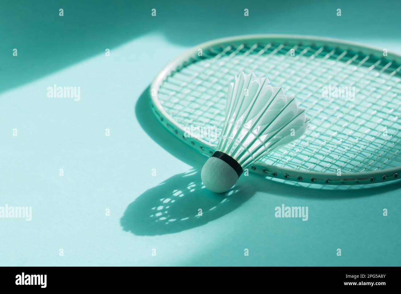 Badminton racket and shuttlecock on mint color background. Horizontal