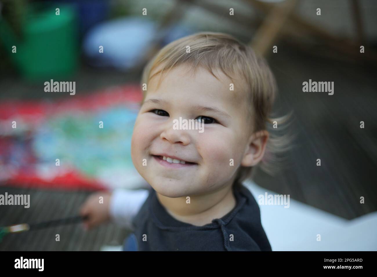 Happy baby sitting outdoors smiling Stock Photo
