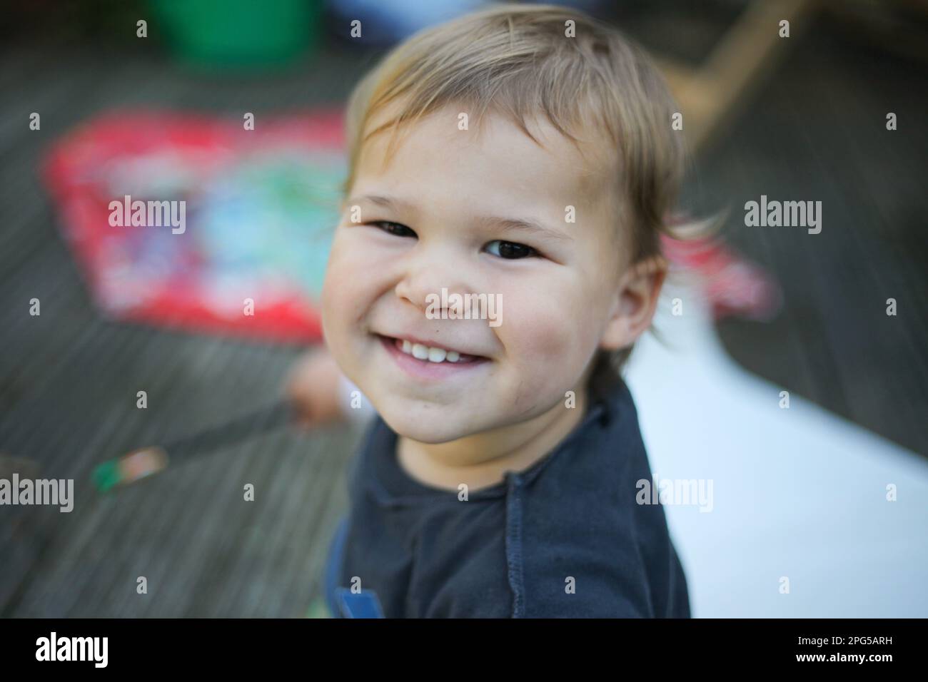 Happy baby sitting outdoors smiling Stock Photo