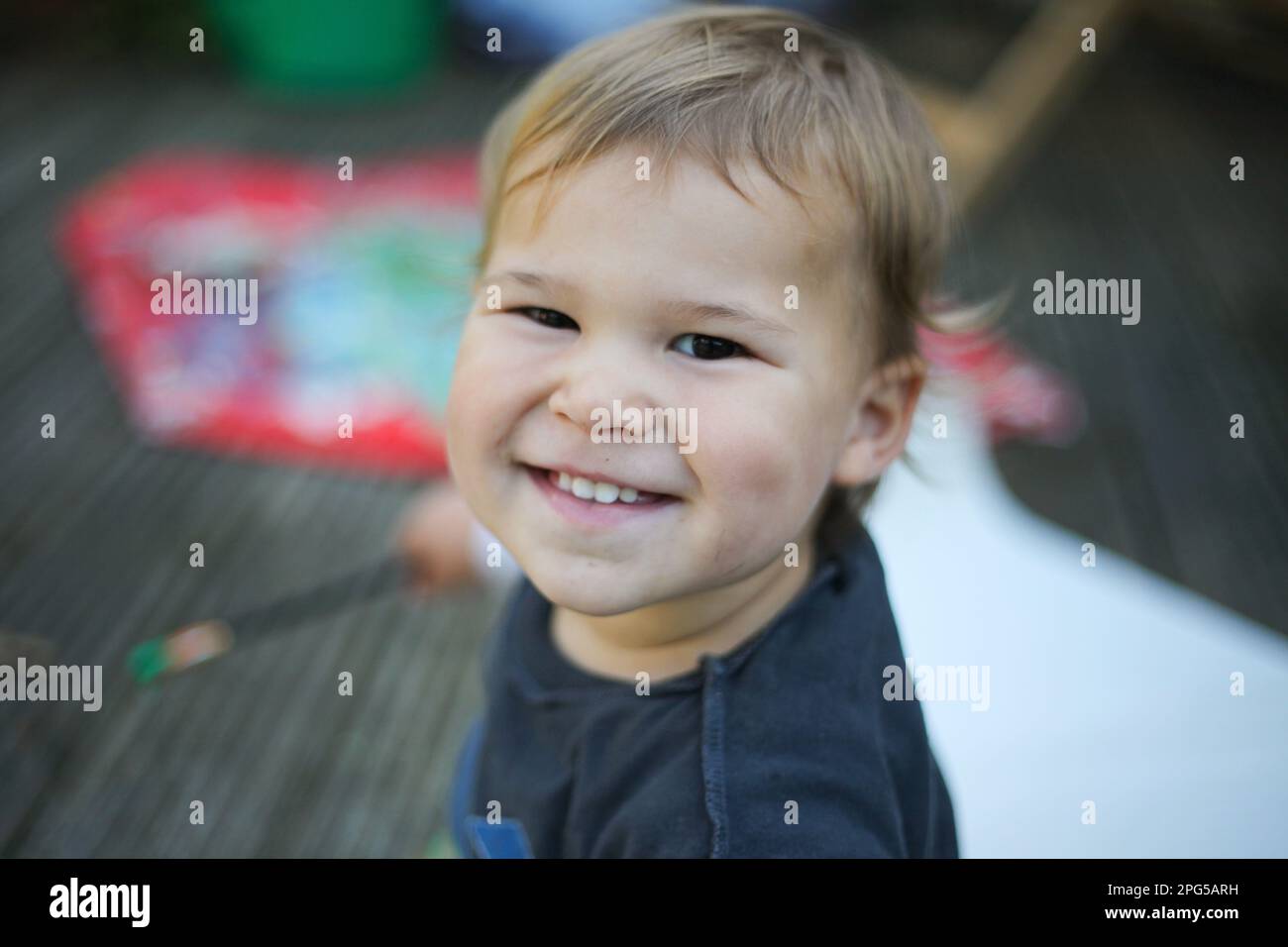 Happy baby sitting outdoors smiling Stock Photo - Alamy