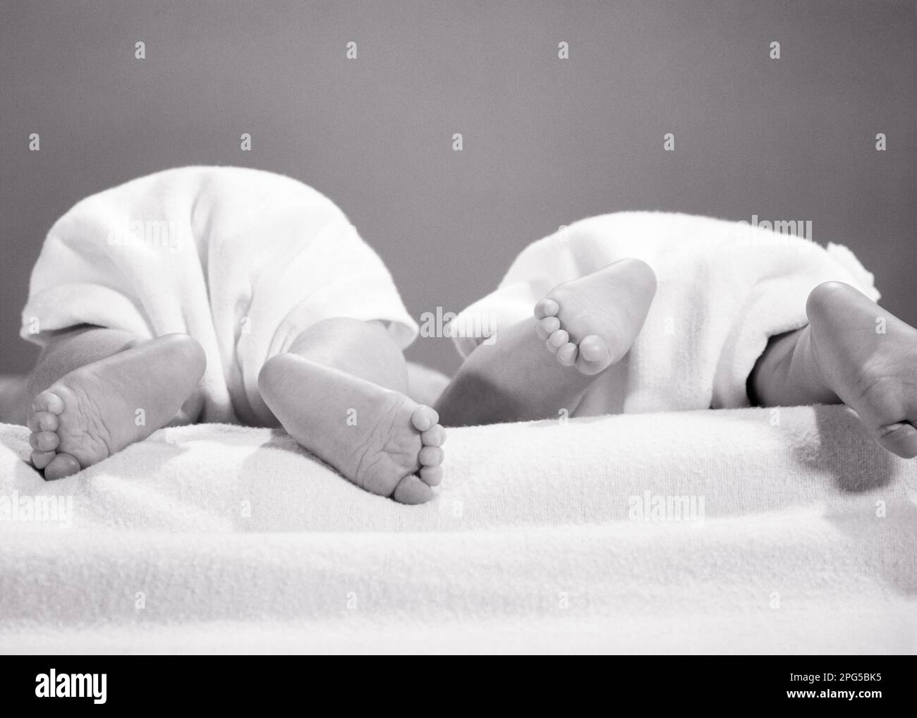 1960s REAR VIEW OF TWO TWIN BABIES BOTTOMS IN CLOTH DIAPERS AND SOLES