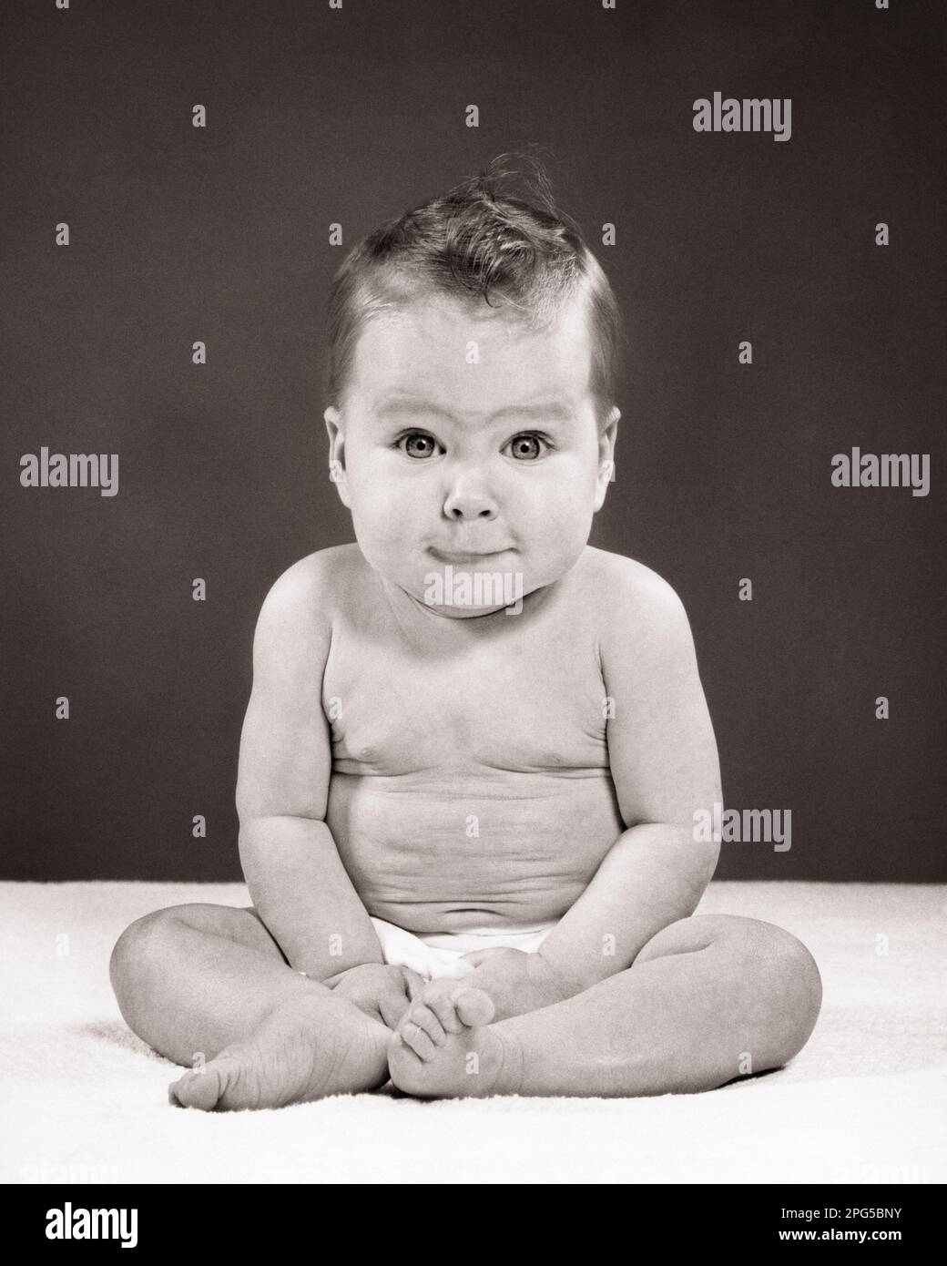 1950s BABY GIRL SITTING UP FULL LENGTH FUNNY FACIAL EXPRESSION LOOKING AT CAMERA - b7488 HAR001 HARS LIFESTYLE SATISFACTION FEMALES WINNING STUDIO SHOT HEALTHINESS HOME LIFE COPY SPACE FULL-LENGTH CONFIDENCE EXPRESSIONS B&W WIDE EYE CONTACT BUG-EYED HUMOROUS HAPPINESS DISCOVERY COMICAL UP BUDDHA SMILES COMEDY JOYFUL PLEASANT WIDE-EYED AGREEABLE CHARMING GROWTH JUVENILES LOVABLE PLEASING STARTLED ADORABLE APPEALING BABY GIRL BLACK AND WHITE CAUCASIAN ETHNICITY HAR001 OLD FASHIONED Stock Photo