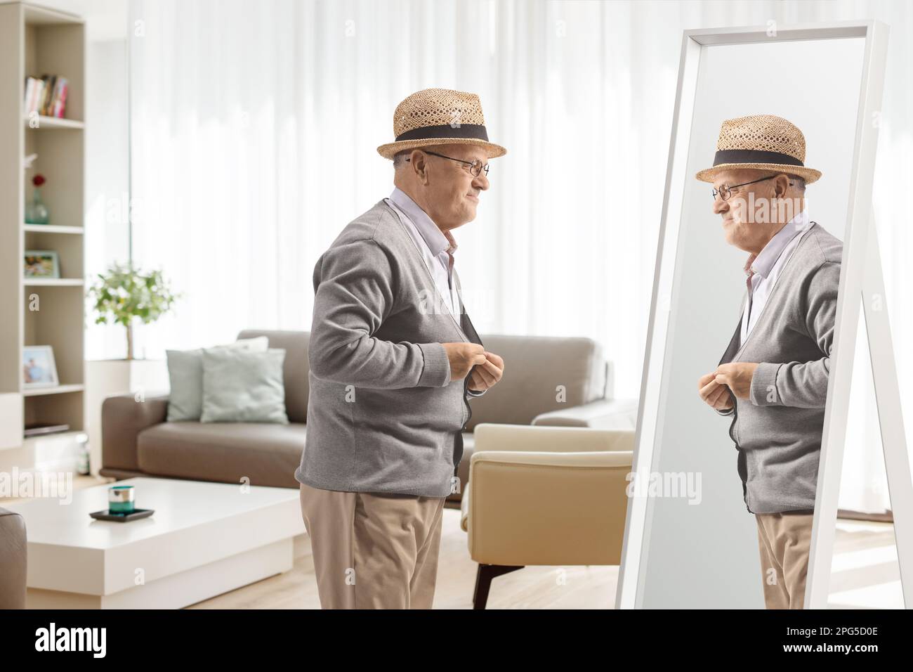 Elderly man getting dressed in front of a mirror at home Stock Photo