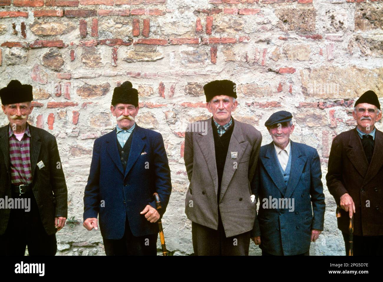 1980s LOCAL SENIOR YUGOSLAVIAN MEN WEARING TRADITIONAL CLOTHES HATS LOOKING AT CAMERA LAKE OHRID SINCE 1991 PART OF MACEDONIA - kr23836 SPE001 HARS HALF-LENGTH PERSONS INSPIRATION TRADITIONAL MALES SENIOR MAN SENIOR ADULT EUROPE EYE CONTACT MUSTACHE OLD AGE OLDSTERS CHEERFUL OLDSTER EUROPEAN MUSTACHES AND PRIDE PART FACIAL HAIR LOCAL POLITICS SMILES ELDERS CONNECTION 1991 CULTURE JOYFUL ELDERLY MAN COOPERATION TOGETHERNESS CAUCASIAN ETHNICITY OLD FASHIONED Stock Photo