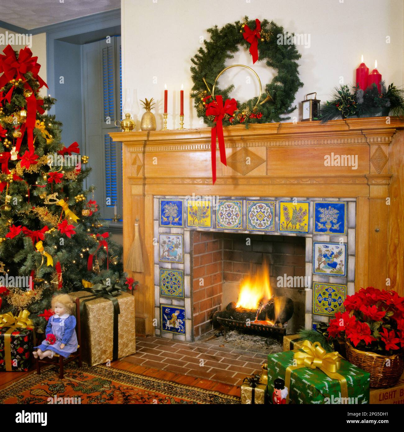 1980s LIVING ROOM WITH WREATH AND CANDLES ABOVE TILED FIREPLACE CHRISTMAS TREE AND WRAPPED PRESENTS  - kx11400 BAR007 HARS DECEMBER 25 INTERIOR DESIGN STYLISH TILED CREATIVITY HOME DECOR JOYOUS YULE FURNISHINGS OLD FASHIONED Stock Photo