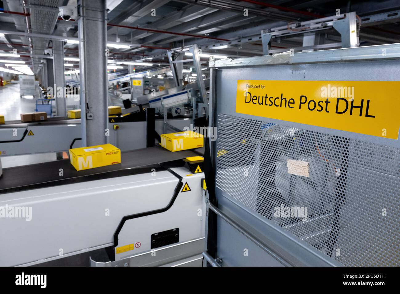 Aschheim, Germany. 20th Mar, 2023. Parcels lie on a conveyor belt in the new DHL parcel center