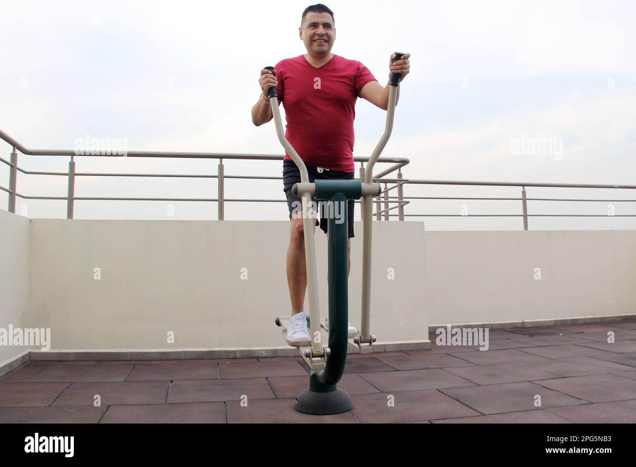 Adult 40yearold Latino man exercises on the roof garden of her