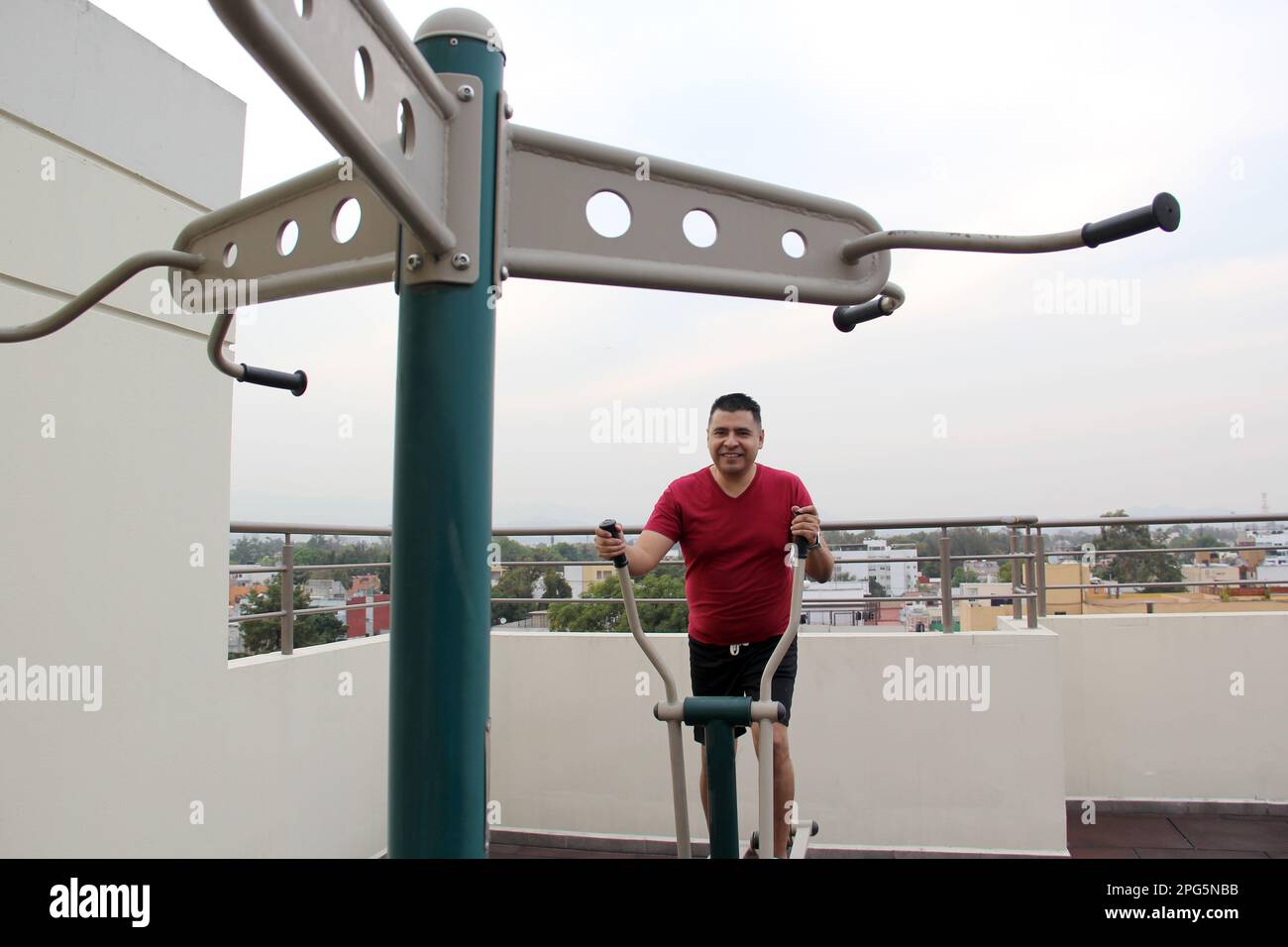 Adult 40yearold Latino man exercises on the roof garden of her