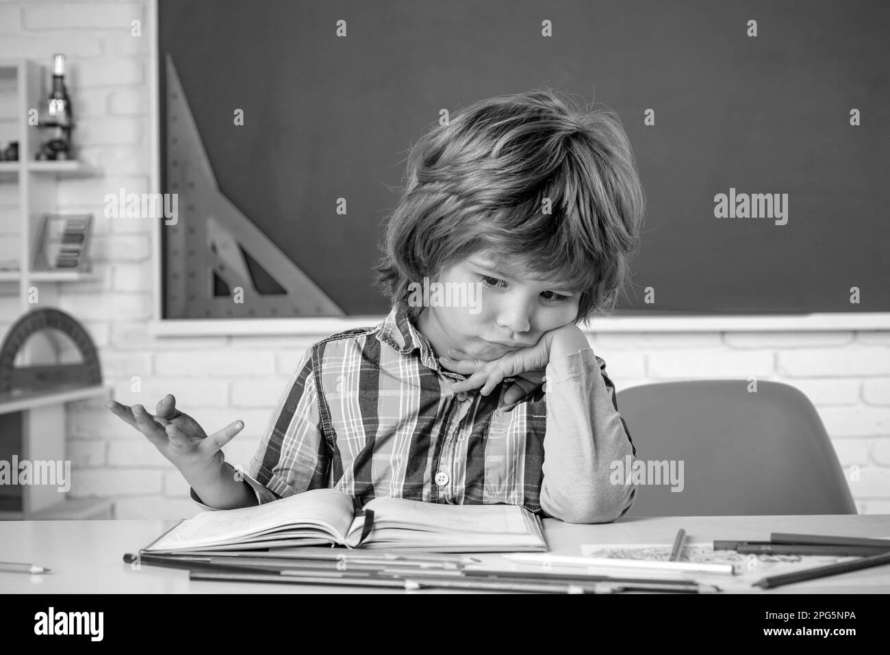 School kids against green chalkboard. Kid gets ready for school. School education and people concept - cute pupil over blackboard background. Stock Photo