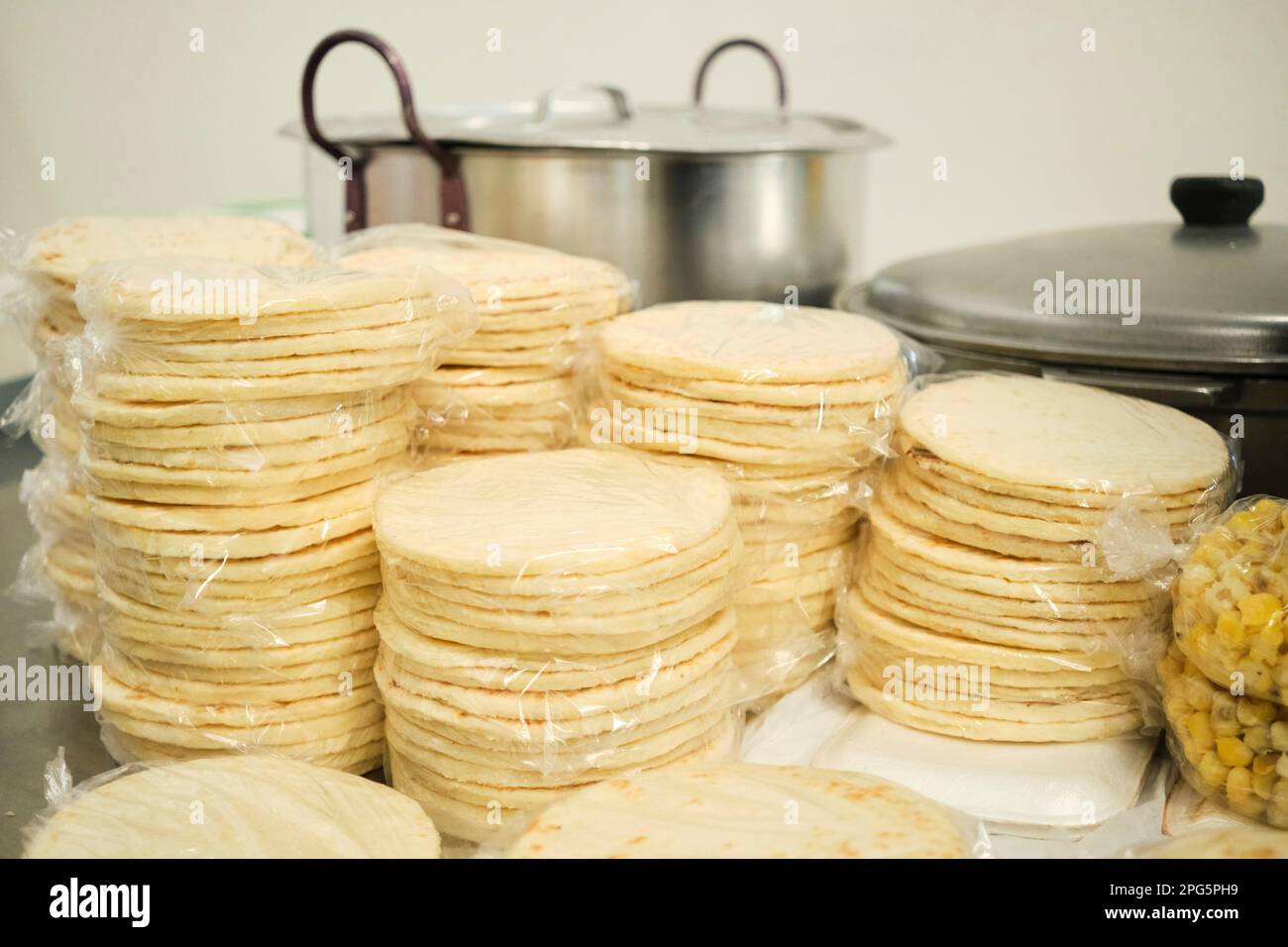 Packages of freshly made traditional arepas ready to be sold in a Colombian market. Stock Photo