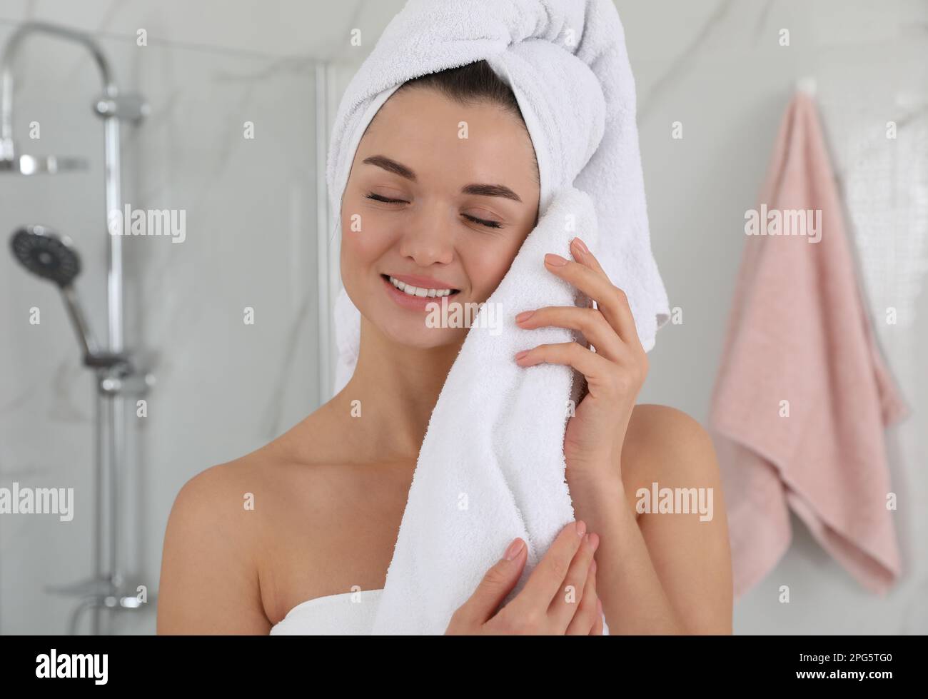 Beautiful young woman with hair wrapped in towel indoors Stock Photo Alamy