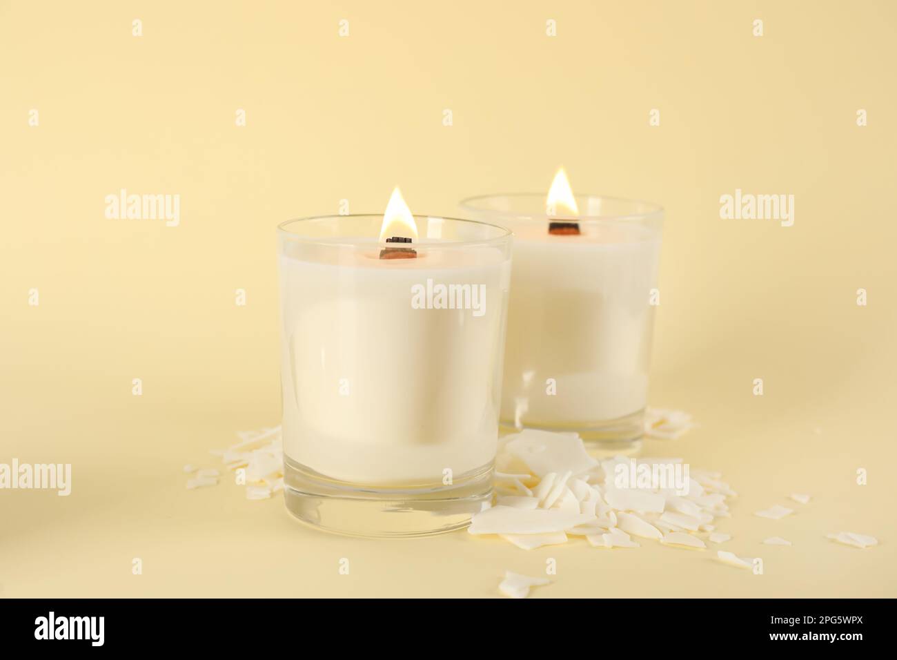 Burning soy candles and wax flakes on beige background Stock Photo Alamy