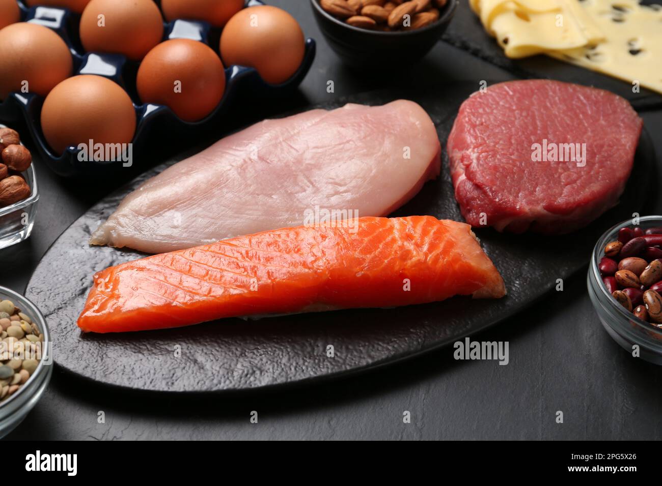 Fresh meat and other products on black table. Sources of essential