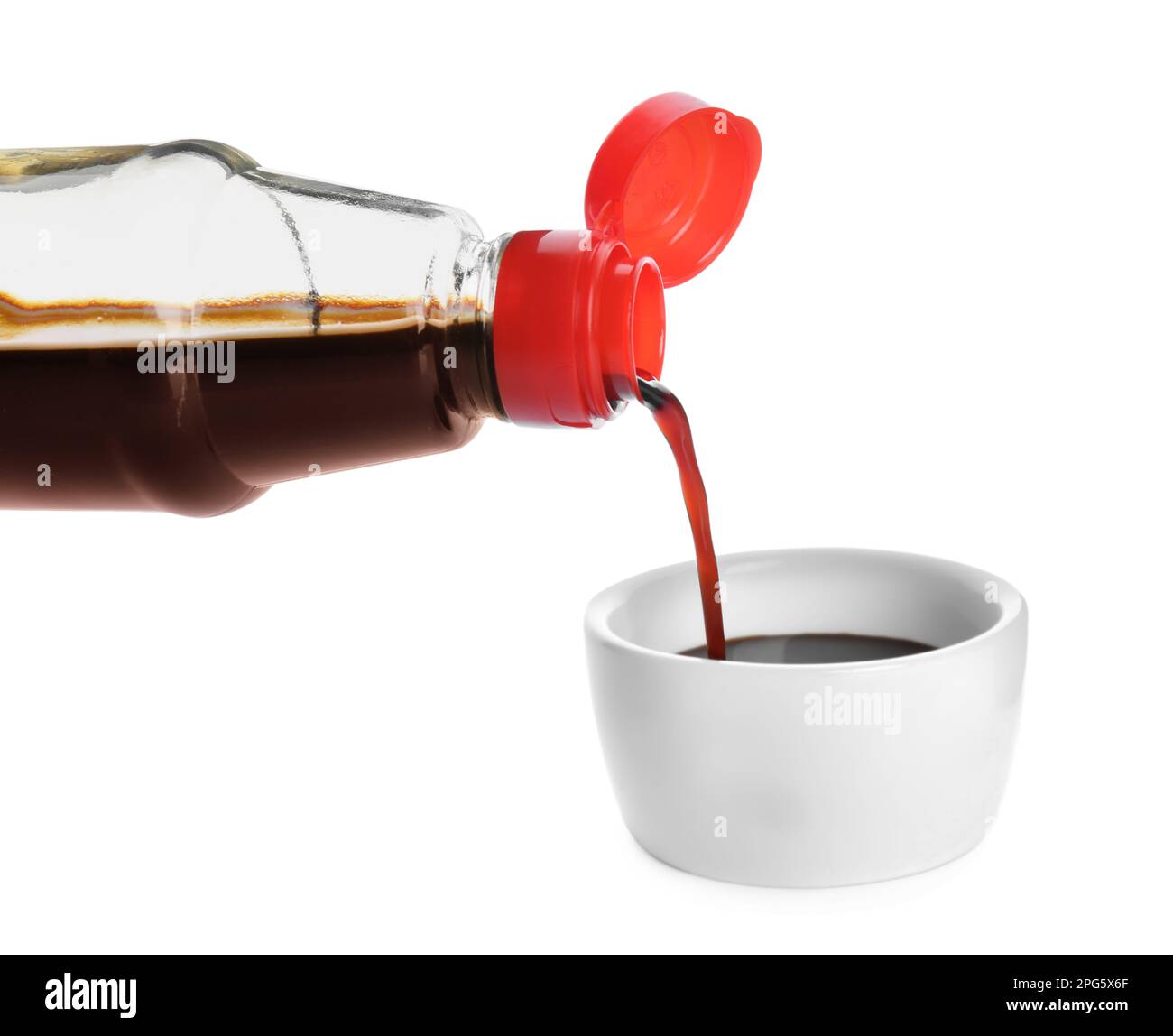 Pouring soy sauce into bowl against white background Stock Photo Alamy