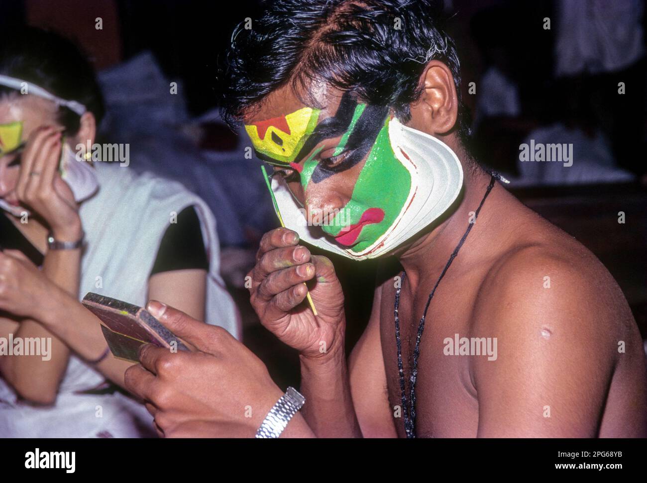 A Katakali artist applying makeup, very elaborate process in Kerala
