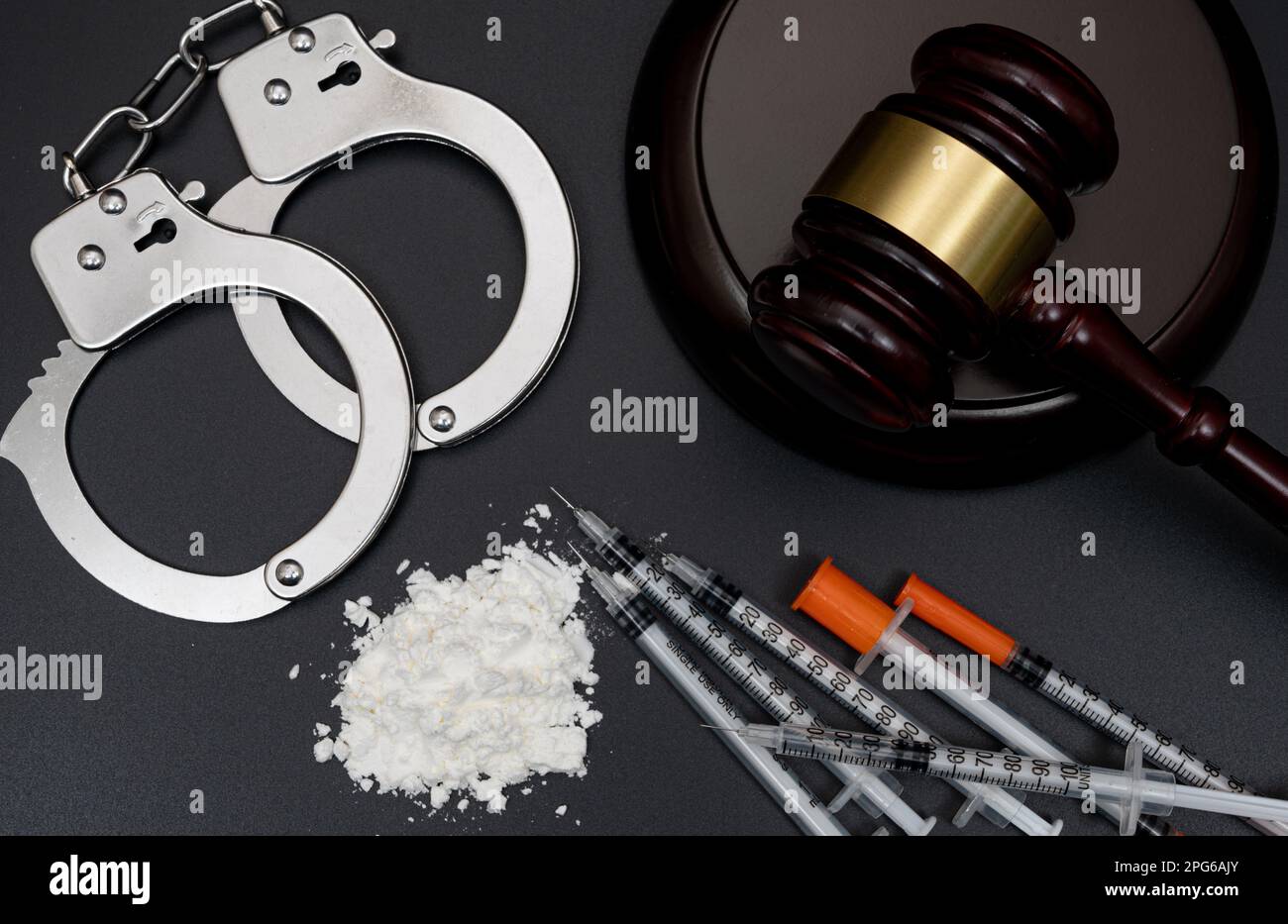 Drug crime concept with white powder and disposable syringe on black background Stock Photo