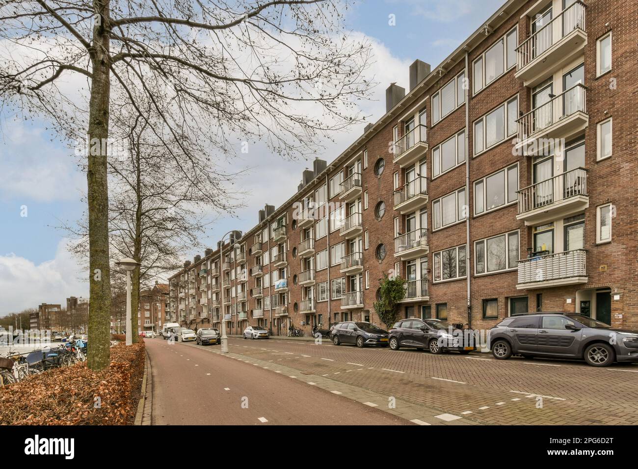 a street with cars parked on the side and buildings in the back ground ...