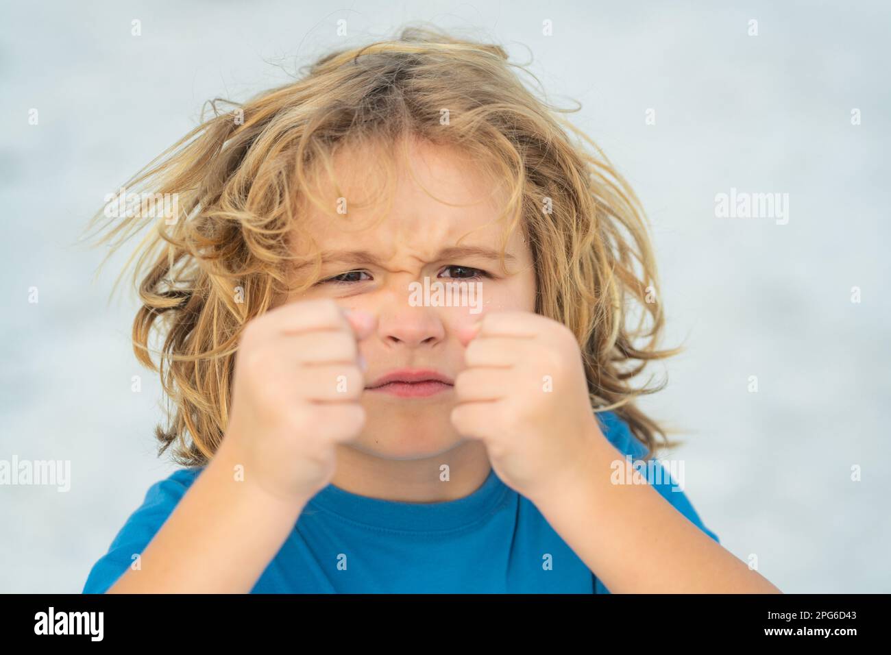 Child temper with angry expression. Angry hateful little anger boy, child furious. Angry rage kids face close up. Anger hateful child with furious Stock Photo