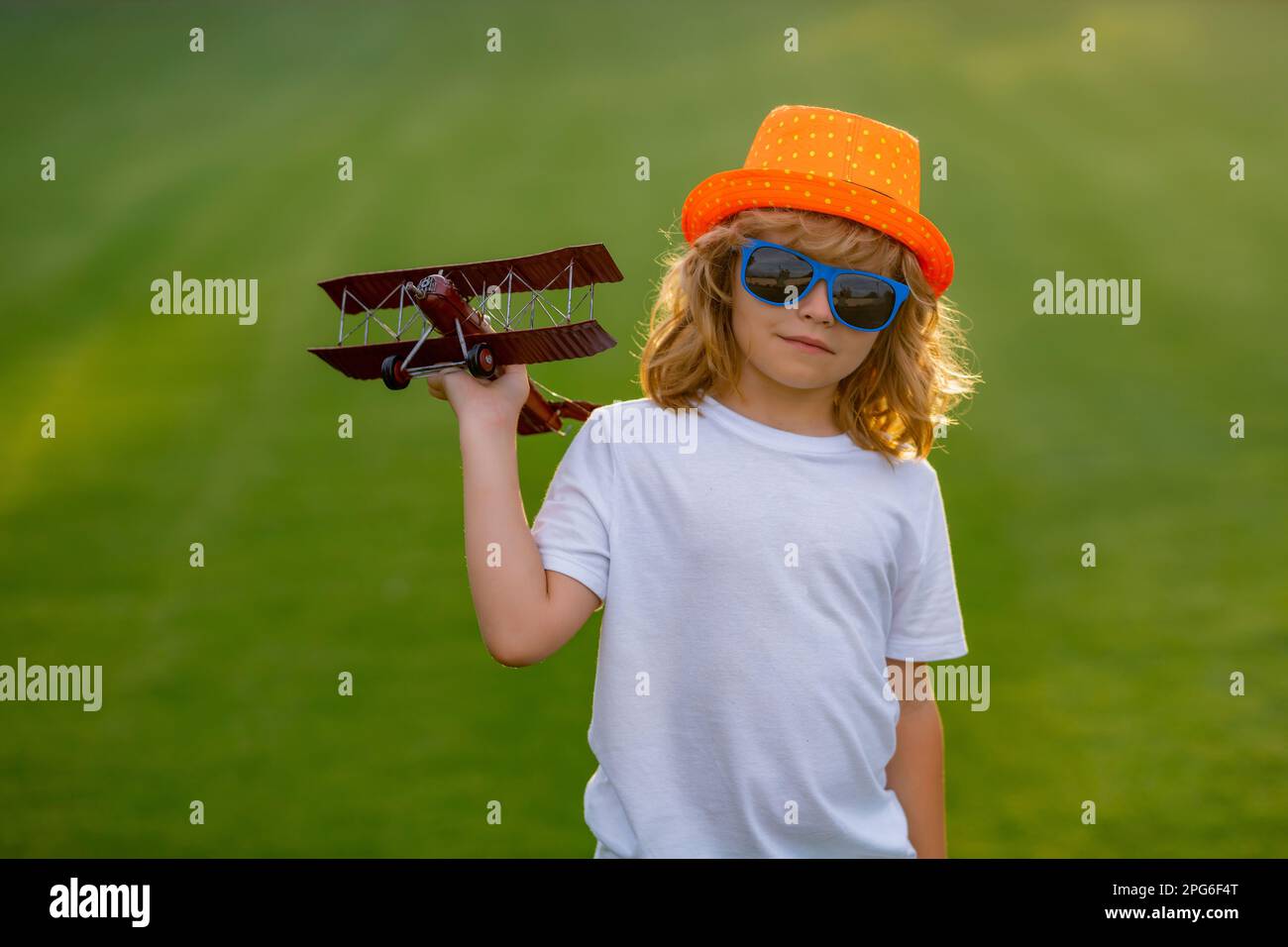 Happy childhood. Child boy toddler playing with toy airplane wings and ...