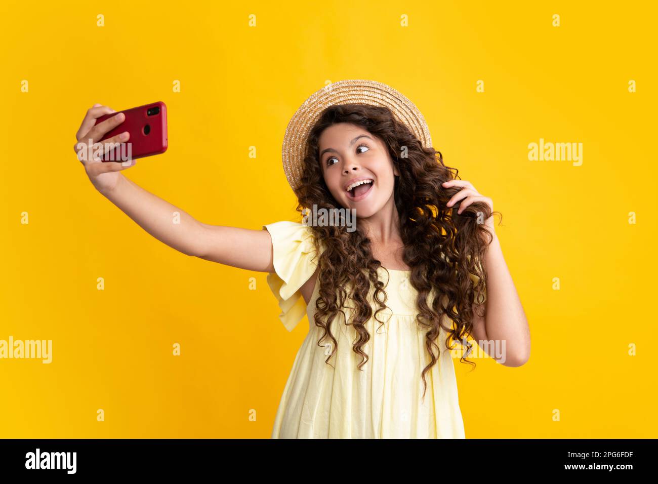 Teenager child girl holding smartphone. Hipster girl with cell phone. Kid hold mobile phone texting in online social networks. Happy teenager, positiv Stock Photo