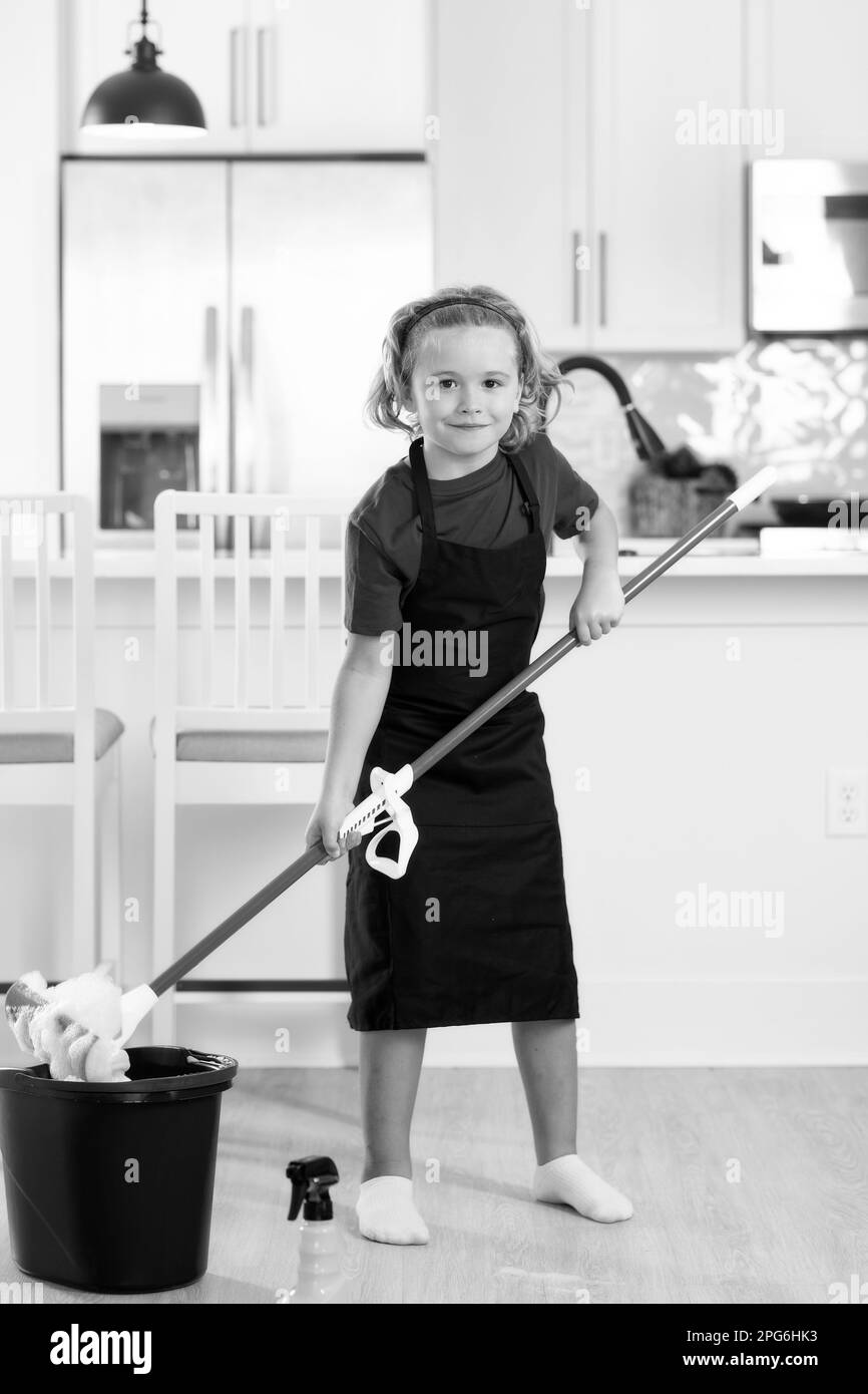 Kid helping with housework, cleaning. Portrait of child helping with