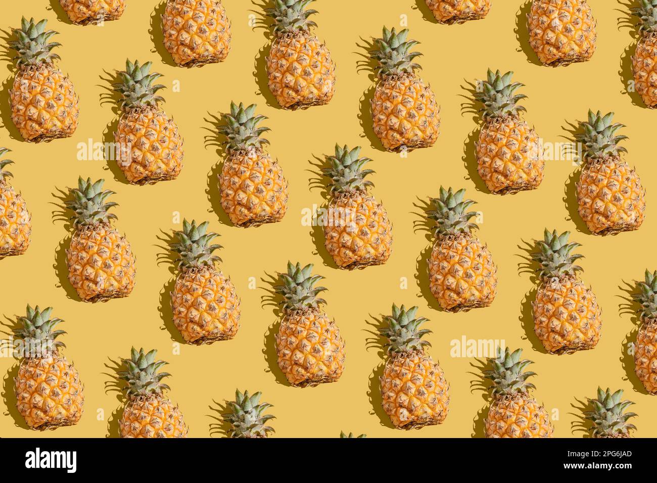 pineapple on a yellow background pattern, pineapple laid out on the background Stock Photo