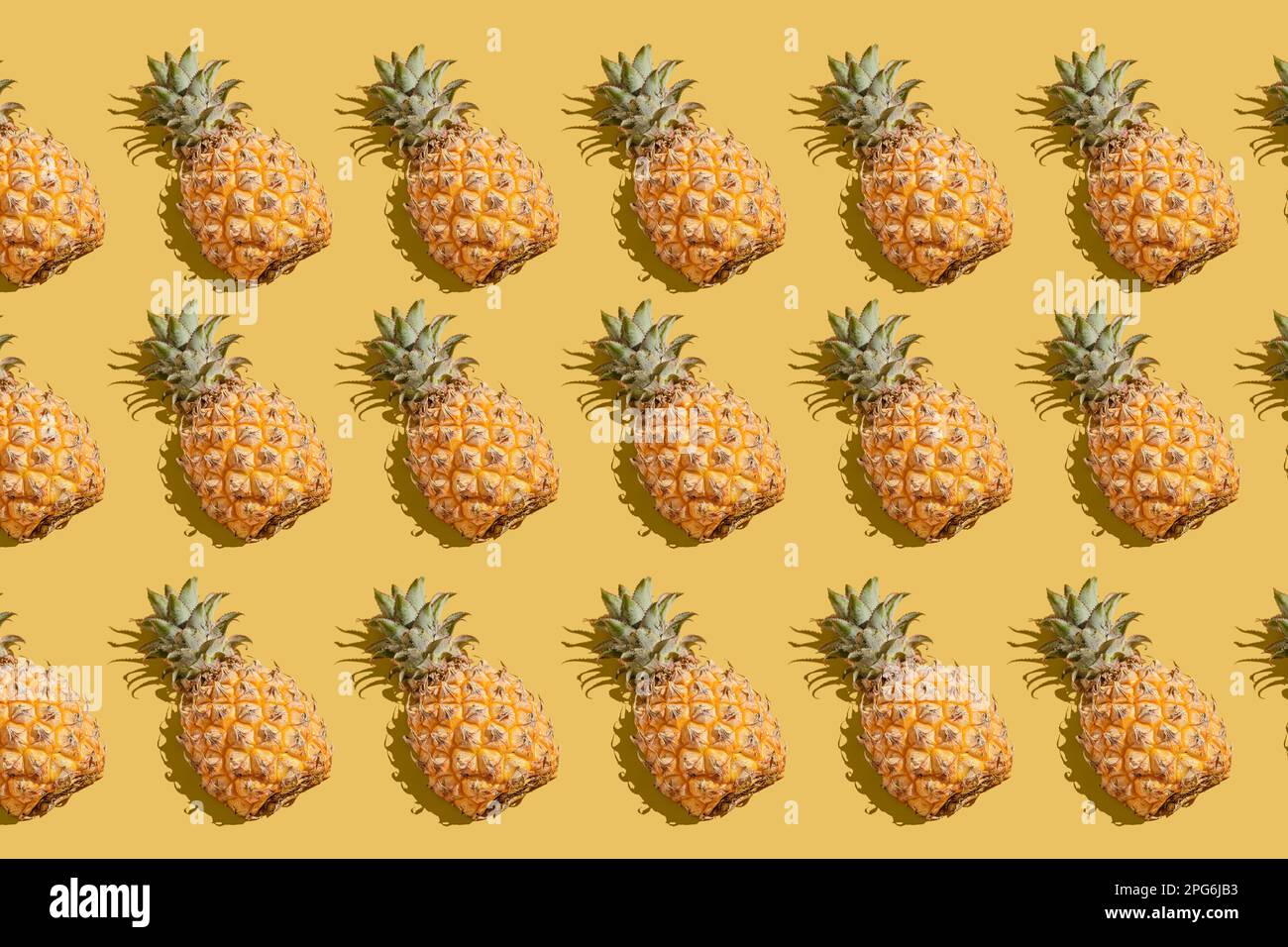 pineapple on a yellow background pattern, pineapple laid out on the background Stock Photo