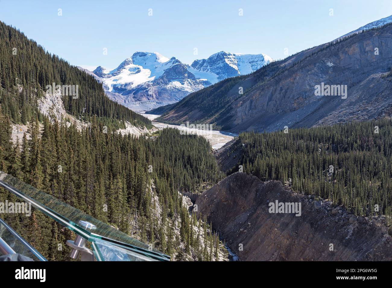 Wilcox Peak from the Columbia Icefield Skywalk in Jasper Park in Canada above  a glacier with a glass railing in the foreground and a clear blue sky Stock Photo