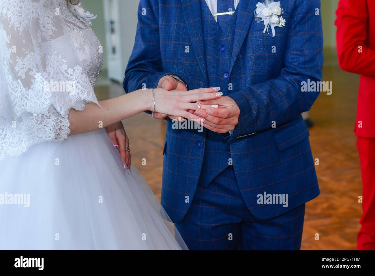 The groom puts a ring on the bride. Married couple exchange wedding