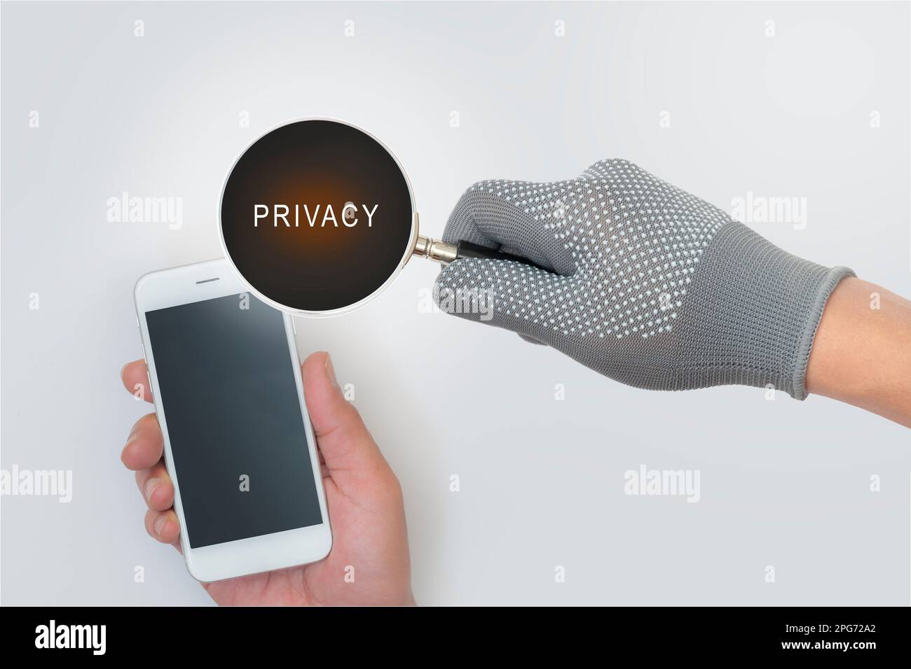 Magnifying glass of fraudsters. Data theft. and privacy in using the internet and smartphones . Stock Photo