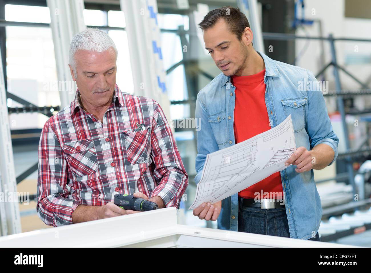 men in factory making made to measure windows Stock Photo