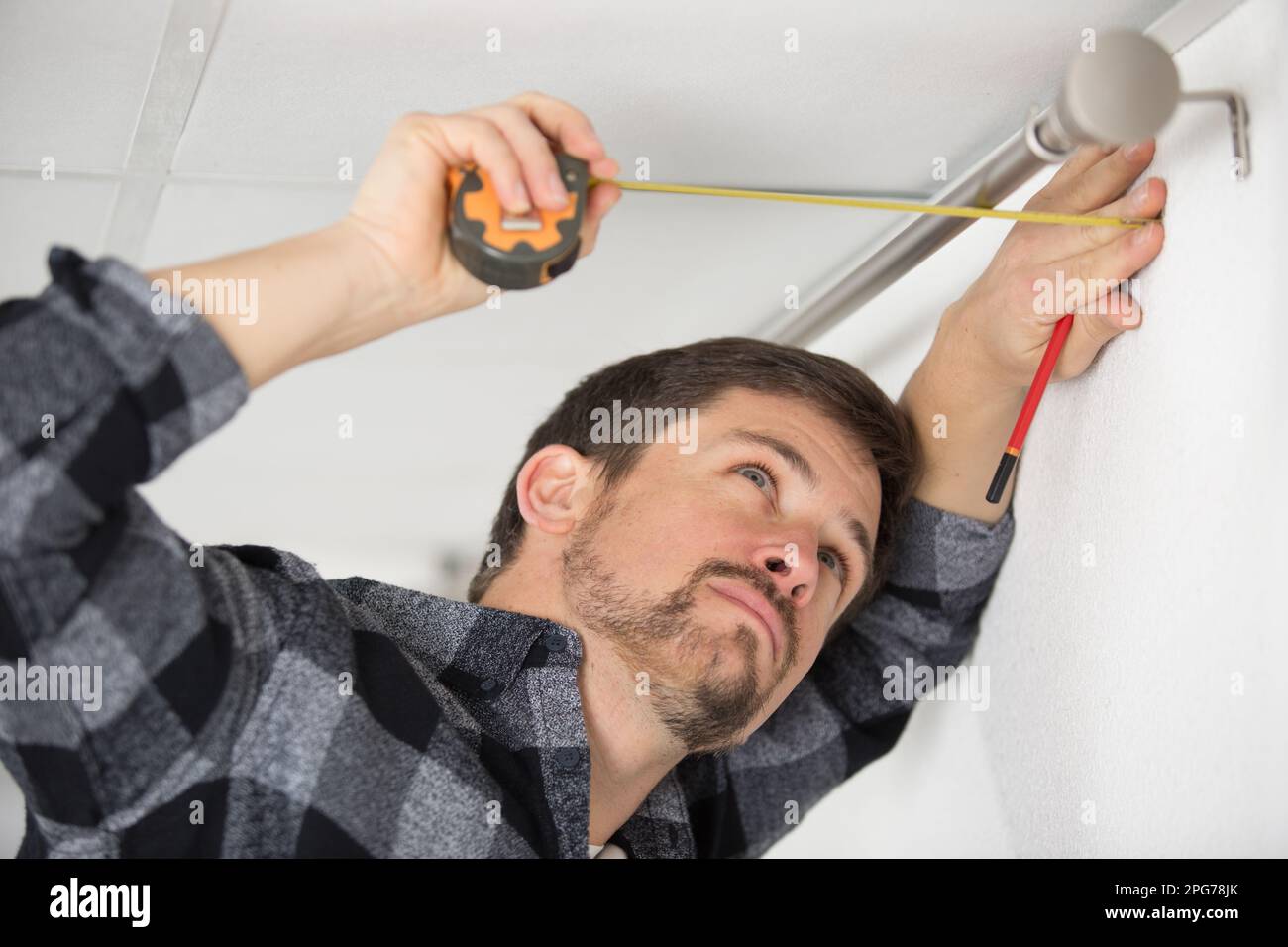 builder measuring curtain rod Stock Photo Alamy