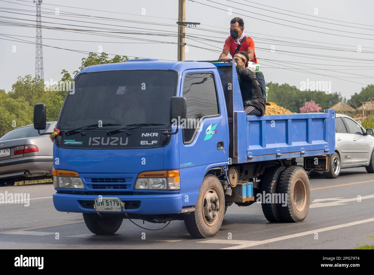 BANGKOK, THAILAND, MAR 11 2023, Men sit on the back of a moving truck