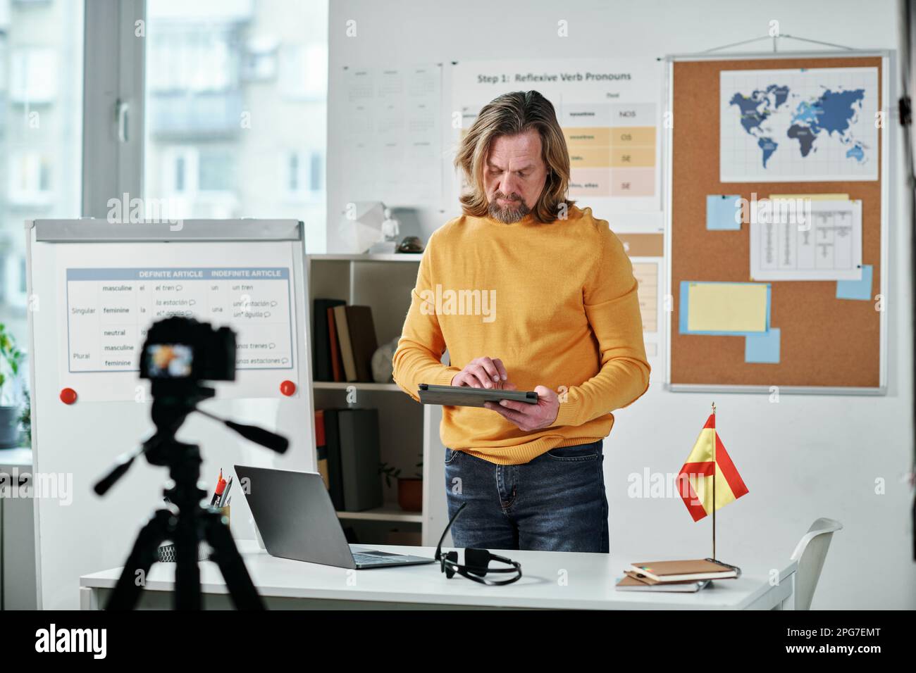 Mature teacher working with tablet pc in the classroom while recording online lesson on professional camera Stock Photo