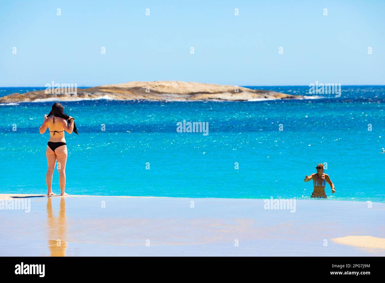Cape Town, South Africa - February 18, 2023: Young female vacationers on Camps Bay beach Stock Photo